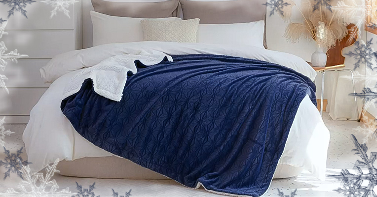A blue faux fur throw blanket spread across the bed